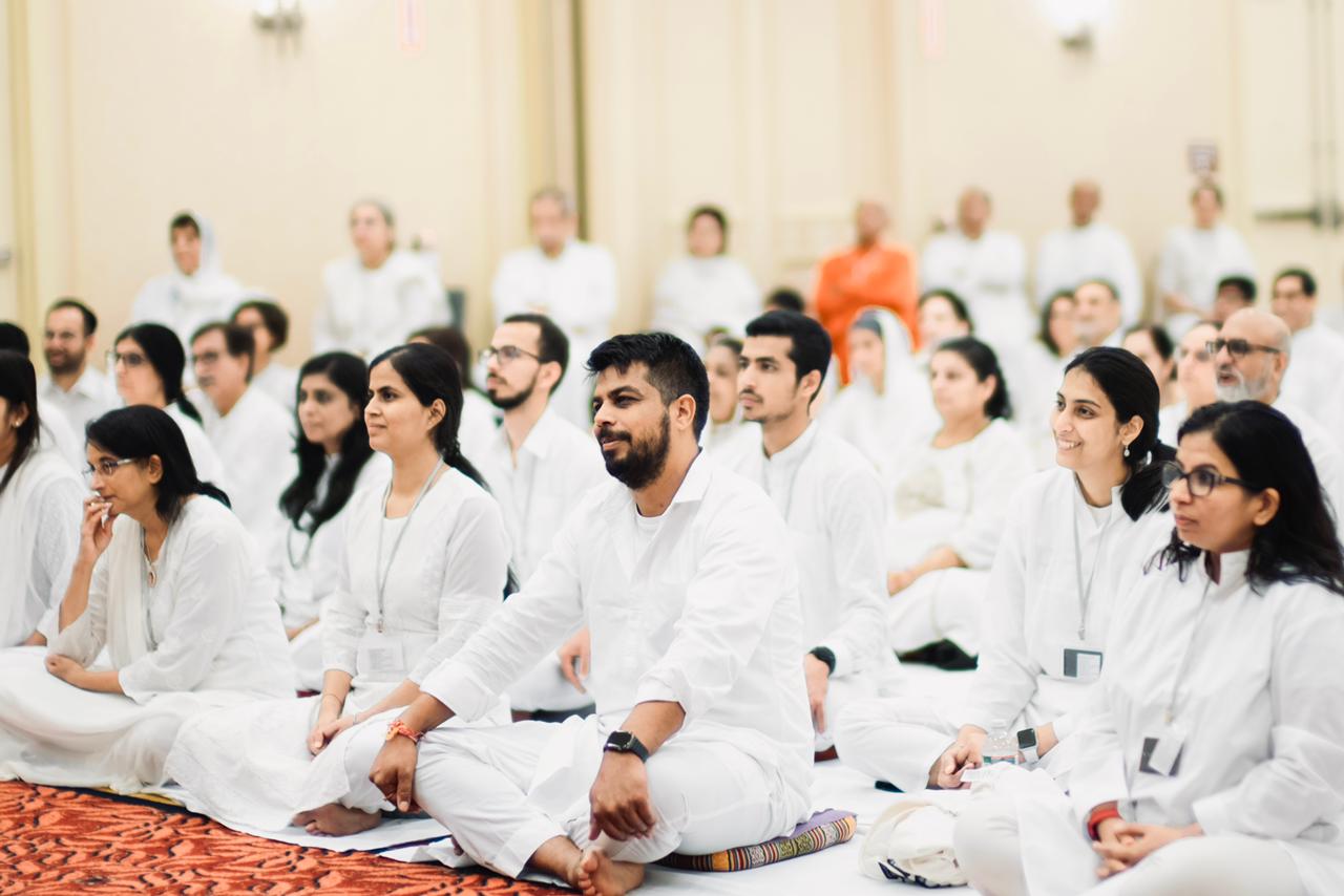 Seekers sitting together in white at a Rishi's Vision gathering