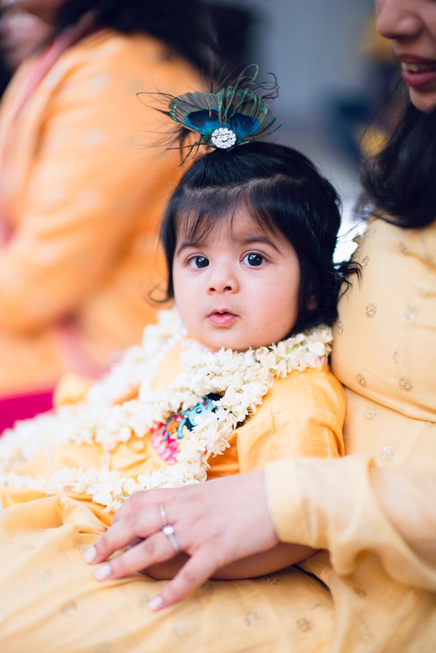 A young child garlanded with jasmine at a celebration