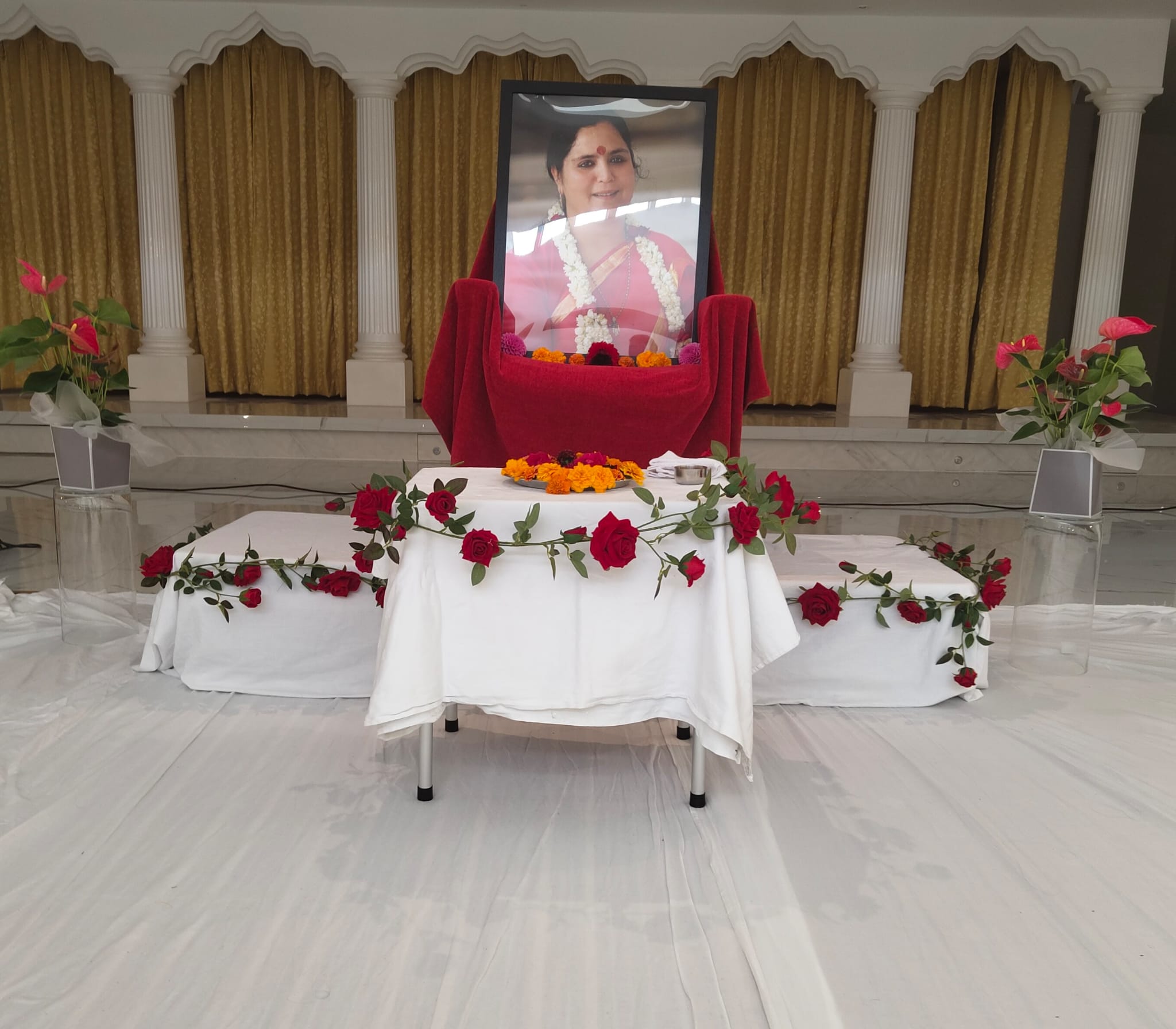 A framed portrait and flowers set at the front of the hall